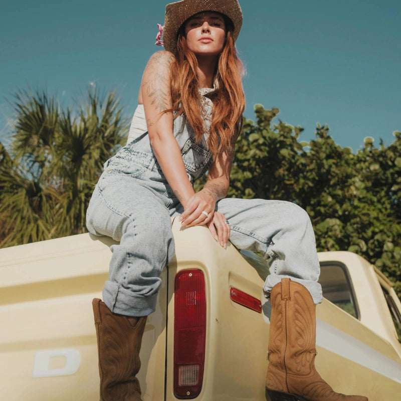 Jeune femme portant des santiags sur un Truck Yehaw